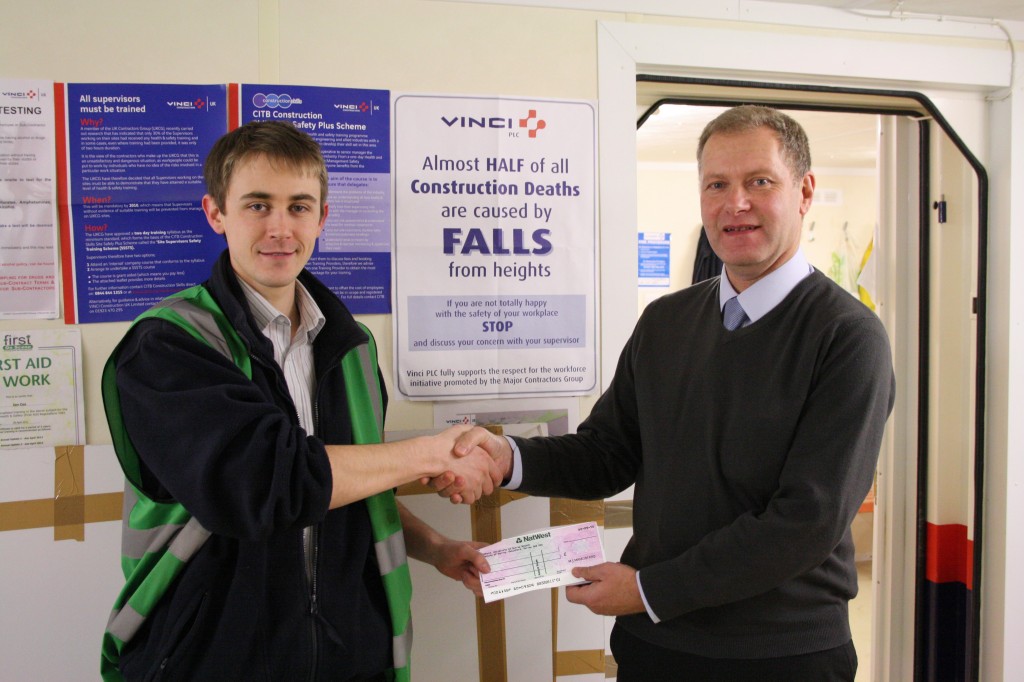 Consultant Peter Staniland (right) presents Vinci Construction's Liam Swords (left) with a donation from Dutton International